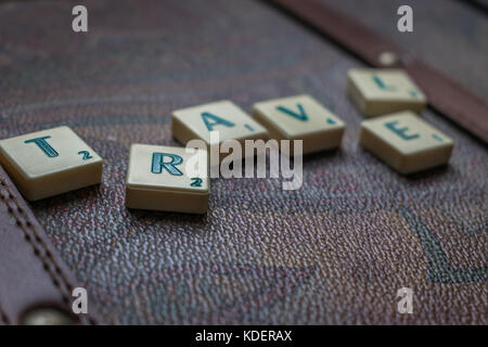 Reisen die Welt scrabble tiles Leder Koffer Hintergrund Stockfoto