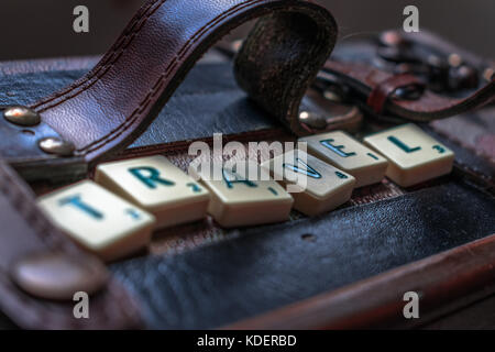 Reisen die Welt scrabble tiles Leder Koffer Hintergrund Stockfoto