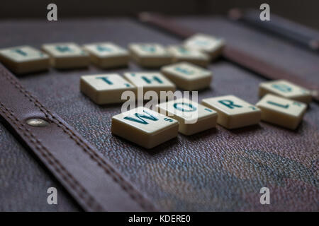 Reisen die Welt scrabble tiles Leder Koffer Hintergrund Stockfoto