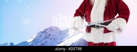 Digital composite von Santa Claus im Winter mit Maßband um die Hüfte Stockfoto