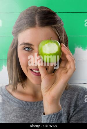 Digital composite von Frau gegen Holz mit Apple über Auge Stockfoto