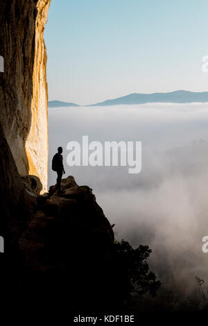 Aitzulo Höhle mit Silhouette einer Person, Meer aus Wolken und Bergen – Herbstmorgen im Baskenland Stockfoto