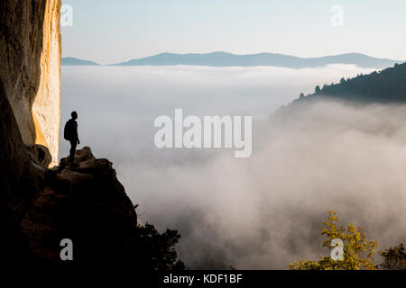 Aitzulo Höhle mit Silhouette einer Person, Meer aus Wolken und Bergen – Herbstmorgen im Baskenland Stockfoto