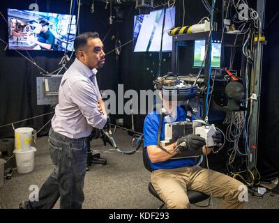 Nasa Extra vehicular activity Trainer Steve vilano Trainer der NASA-Astronaut nick Haag, wie er eine Virtual reality Simulator verwendet für einen Außenbordeinsatz Notfalltraining Szenario mit dem vereinfachte Hilfen für eva Rescue (sicherere) Pack am Johnson Space Flight Center Virtual Reality Lab am 26. April 2017 in Houston, Texas. (Foto von J.m. eddins jr. über planetpix) Stockfoto