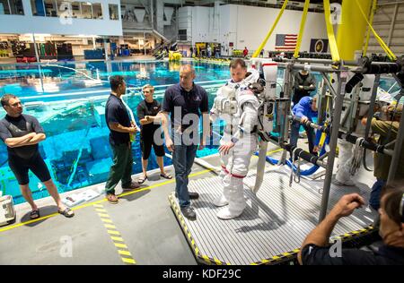 Der kanadische Astronaut David saint jacques der kanadischen Raumfahrtagentur hilft der NASA-Astronaut nick Haag auf einen Raumanzug und Helm, wie er sich vorbereitet für Extra Vehicular Activity spacewalk Training am Johnson Space Flight Center natürliche Buoyancy Laboratory am 27. April 2017 in Houston, Texas. Haag bereitet sich auf seinem Flug 2018 an die Internationale Raumstation an Bord der Sojus-56 s Sonde mit Expedition 57/58. (Foto von J.m. eddins jr. über planetpix) Stockfoto