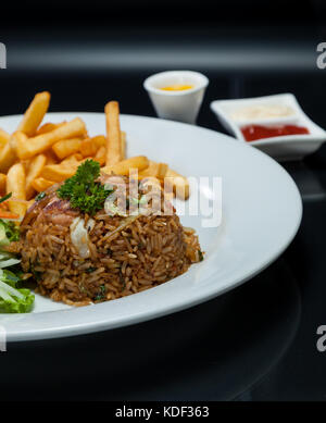 Restaurant mit Hühnerfleisch gebratener Reis mit Salat und frische Pommes frites Stockfoto