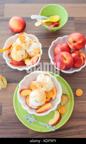 Kugeln Eis mit frischen Nektarinen und Physalis Stockfoto