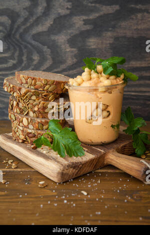 Hausgemachte Hummus mit in Scheiben geschnittenen frischen Vollkornbrot Stockfoto