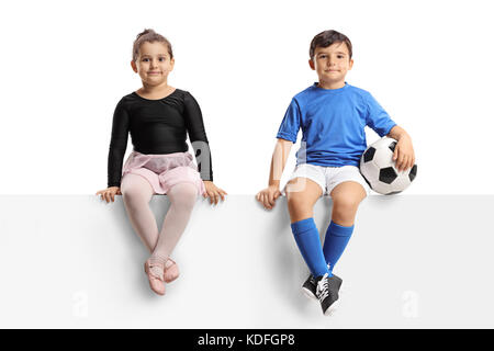 Kleine Ballerina und einem kleinen Fußballer sitzen auf einem Panel auf weißem Hintergrund Stockfoto