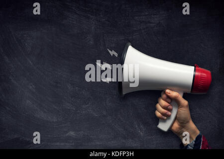 Hand mit Megaphon auf Schiefertafel mit Kopie Raum Stockfoto