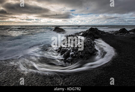 Flutwellen Umkreisen der Felsen von Djúpalónssandur schwarzer Sandstrand, Dritvik, Halbinsel Snaefellsnes, Island Stockfoto