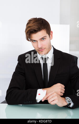 Portrait einer jungen Geschäftsmann mit Spielkarten in der Hülse Stockfoto