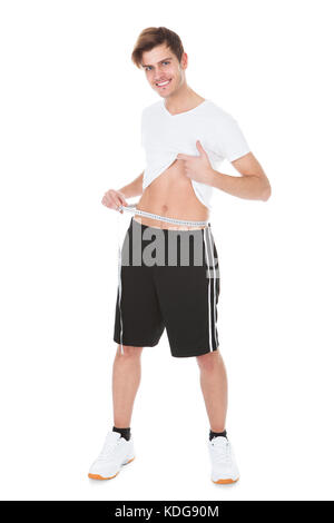 Porträt eines glücklichen jungen Mannes seiner Taille messen Stockfoto