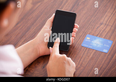 Nahaufnahme der Geschäftsfrau Zahlung mit Kreditkarte auf Handy Stockfoto