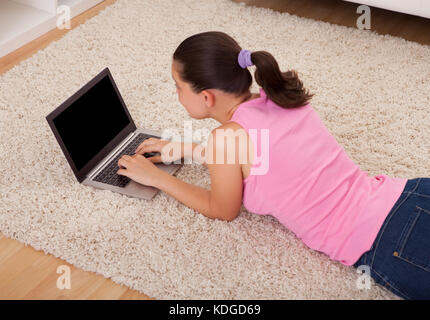 Junge schöne Frau mit Laptop im Wohnzimmer Stockfoto