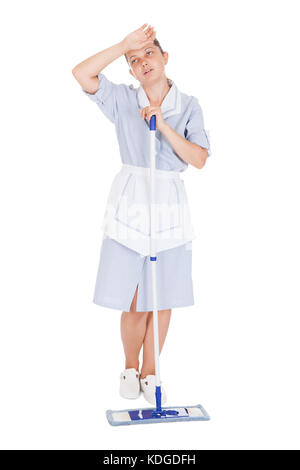 Müde Zimmermädchen Reinigung Boden mit Mop auf weißem Hintergrund Stockfoto