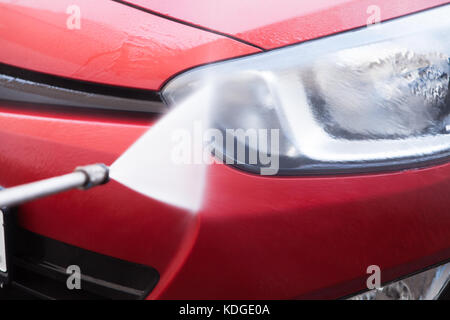 Nahaufnahme des Schlauches Spritzwasser auf Autoscheinwerfer Stockfoto