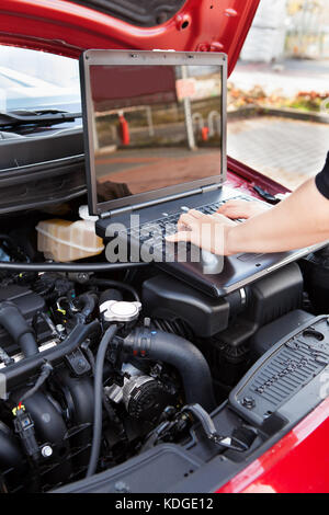 Nahaufnahme von Hand eingeben, auf einem Computer In einer Garage Stockfoto