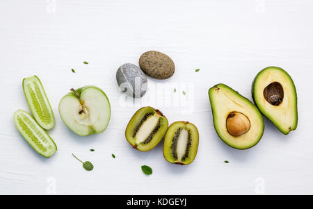 Hausgemachte Hautpflege und Körperpeeling mit natürlichen Zutaten grüne Gurke, Avocado, grüner Apfel, Kiwi, und spa Stone setup auf weißem Holz- Hintergrund Stockfoto