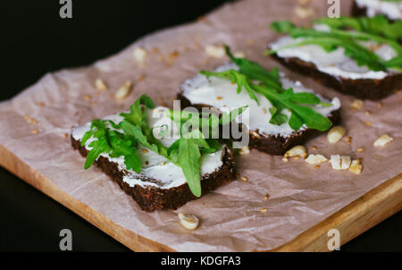 Vegetarische Sandwiches auf Vollkornbrot, Weichkäse, Walnüsse und Rucola Stockfoto