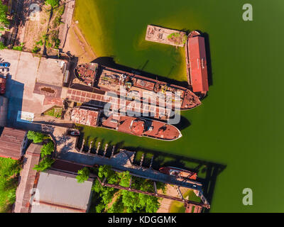 Luftaufnahme, zwei alte, rostige Lastkähne, an der Pier auf dem Fluss Stockfoto