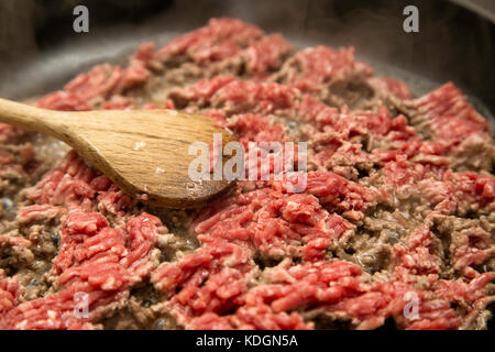 Hackfleisch in einer Pfanne, holzspachtel in der Pfanne und Dampf des Fleisches lügen Fried. Stockfoto