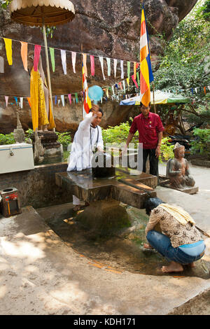 Phnom Kulen, Kambodscha - 20. Februar 2013: die Priester des Klosters mit Weihwasser besprengen Frau Stockfoto