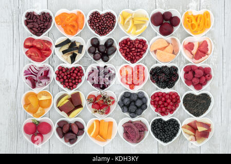 Essen für ein gesundes Leben mit Obst, Getreide, Gemüse und Hülsenfrüchte in Herzform Gerichte auf rustikalem Holz Hintergrund. Gesundheit Lebensmittel Konzept. Stockfoto