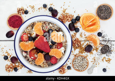 Gesunde Lebensmittel für das Frühstück mit Müsli, frisches Obst, Nüsse, Pollen, Getreide, Joghurt, acai Berry Pulver und Chia Samen. Stockfoto