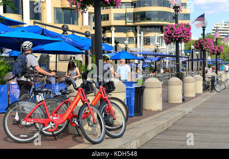 Radfahrer geniessen Sie die Promenade entlang Mixed Use Development Washington's Hafen am Ufer des Potomac River in Washington DC Stockfoto