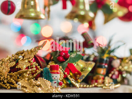 Weihnachtsbaum dekorative Miniaturen, Spielzeug und Requisiten, Glocken, Geschenke und Geschenke, Schneemann und Weihnachten bokeh Lichter im Hintergrund Stockfoto