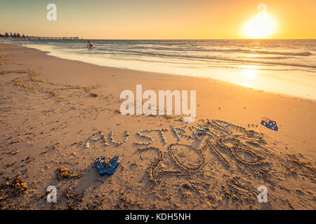 Australien 2018 Text mit Tangas, Flagge und Sonnenbrille am Strand bei Sonnenuntergang Stockfoto