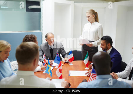 Junge weibliche Delegierte, die während der Konferenz für Kollegen Bericht erstattet Stockfoto