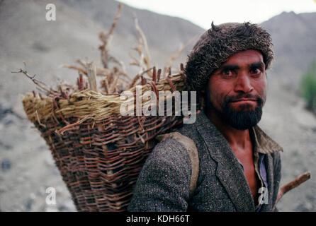 Baltistan, Pakistan, 1990; ein Balitsani Hirte trägt einen Korb von Zweigen auf seinem Rücken, als er Wanderungen durch die Berge in der Nähe von Skardu. Stockfoto