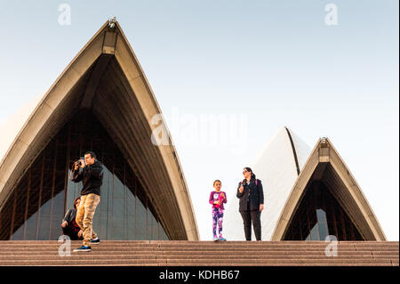 Touristen stehen auf den Stufen des Sydney Opera House mit Blick auf den Blick auf den Hafen von Sydney Australien New South Wales. Stockfoto
