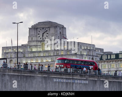 London Bus und Pendler kreuz Waterloo Bridge vor der Shell Mex House in London in der Dämmerung Stockfoto