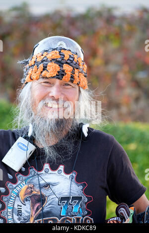 Hafen Dover, Ontario, Kanada, 13. Oktober 2017. Tausende von Motorradfahrern aus ganz Kanada und den Vereinigten Staaten erhalten Sie zusammen für den Freitag, 13. Motorrad Rallye, jeden Freitag den 13. im Hafen von Dover, Ontario, Kanada, seit 1981 statt. Die Veranstaltung ist eine der größten single - Tag Motorrad Ereignisse in der Welt. Dieses Jahr, das milde Wetter beigetragen, die für eine große Anzahl der Biker und Schaulustige, mit Hunderten von custom motorräder, Anbieter, live Musik und interessante Menschen zu sehen. Asiatische Motorradfahrer lächelnd posiert für ein Portrait. Credit: Rubens Alarcon/Alamy leben Nachrichten Stockfoto