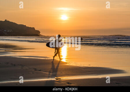 Sennen Cove, Cornwall, UK. 14. Oktober 2017. UK Wetter. Es war ein warmer und sonniger Ende an den Tag ganz im Westen von Cornwall, mit Hund Spaziergänger und Surfer auf den meisten der späten Sonnenschein am Strand. Foto: Simon Maycock/Alamy leben Nachrichten Stockfoto