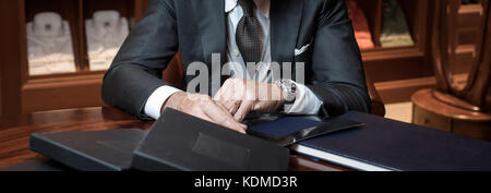 Stilvoller Geschäftsmann am Tisch Stockfoto