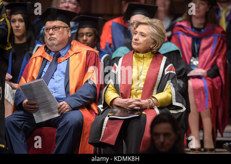 Hillary Clinton sitzt neben Mike Sullivan, dem Sonderberater der Vizekanzlerin, während sie auf den Erhalt einer Ehrendoktorwürde an der Swansea University wartet, in Anerkennung ihres Engagements für die Förderung der Rechte von Familien und Kindern auf der ganzen Welt. Eine Verpflichtung, die von der Beobachtungsstelle für die Menschenrechte von Kindern und Jugendlichen der Universität Swansea geteilt wird. Stockfoto