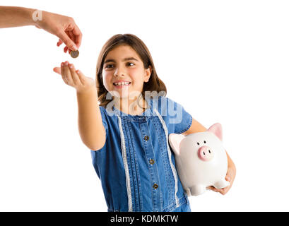 Junge Mädchen ihre Ersparnisse auf einem Sparschwein Stockfoto