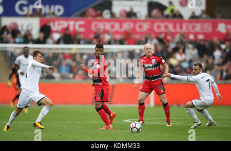 Elias Kachunga aus Huddersfield Town (Mitte) und Tom Carroll aus Swansea City (links) kämpfen um den Ball während des Premier League-Spiels im Liberty Stadium in Swansea. Stockfoto