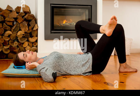 Schöne Frau zu Hause auf dem Boden liegend Stockfoto