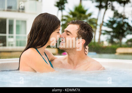 Junges Paar in einem Luxushotel in einem Whirlpool und küssen Stockfoto