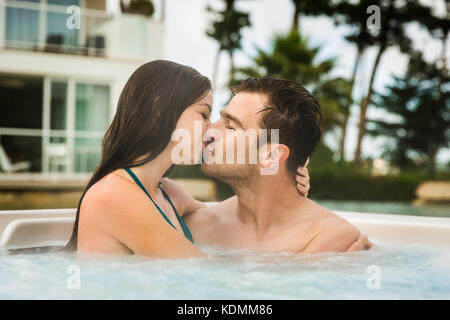 Junges Paar in einem Luxushotel in einem Whirlpool und küssen Stockfoto