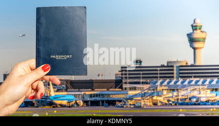 Digital composite von Hand mit einem generischen Reisepass mit hektischen Airport Terminal in verschwommenen Hintergrund Stockfoto