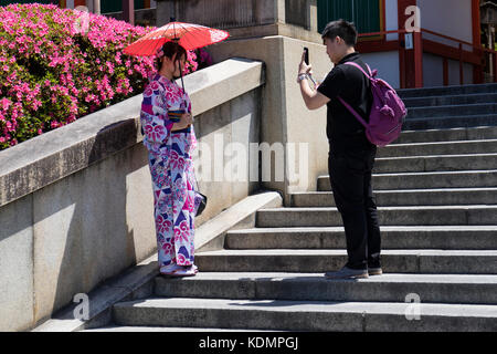 Kyoto, Japan - 19. Mai 2017: traditionell gekleideten Mädchen im Kimono mit Sonnenschirm auf der Treppe des yasaka jinja Schrein fotografiert. Stockfoto