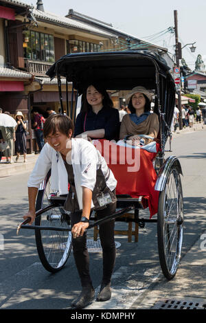 Kyoto, Japan - 20. Mai 2017: Traditionelle human power Rikscha tragen Frauen durch die Stadt Stockfoto