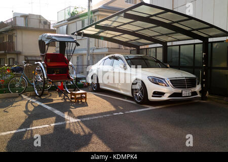Kyoto, Japan - 21. Mai 2017: Rikscha und mercedes-Auto parken zusammen auf der Straße und zeigen alte und neue Verkehrsmittel Stockfoto