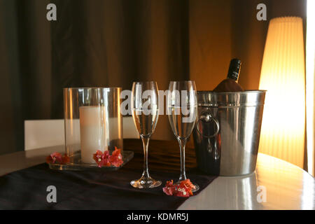 Eine Flasche Prosecco mit zwei Gläsern auf einem Bett in einem tropischen Resort Zimmer. Chatham Bay, Union Island, St. Vincent und die Grenadinen, Karibik. Stockfoto